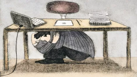 Businessman scared under desk